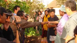 A group of people from different backgrounds greeting each other and taking photographs