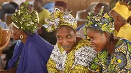 Two women talking to each other at a crowded event.