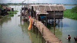 A house on stilts, surrounded by flood water