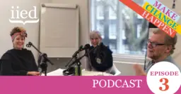 Three people sat around a table speaking into microphones