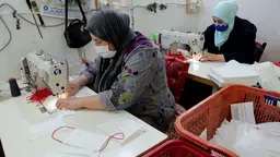 Two women sewing face masks