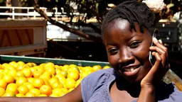 A woman holding a mobile phone and smiling