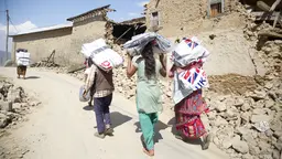 Women carrying emergency shelter kits