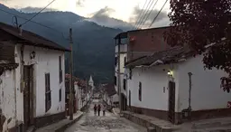 People walking down a street with mountains in the background