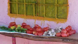 Tomatoes and other vegetables on a shelf outside a house
