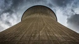 A cooling tower of a power station is framed against the sky
