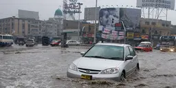 Car driving through a heavily flooded road.