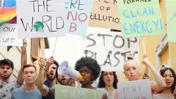 A group of young people protest holding signs about climate change and loudspeakers