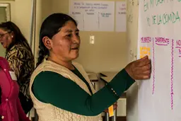 Woman adding stickers to a poster on the wall