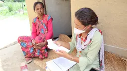 A data collector speaks to a householder.