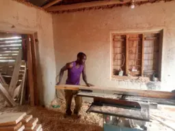 A carpenter uses a jointer powered by a mini-grid