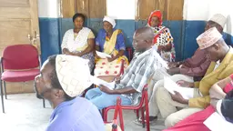 Men and women sitting in chairs.