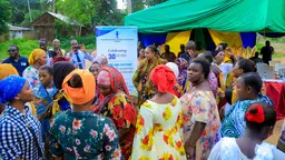Women gathering. Institutional banner in the background. 