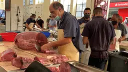 Vendor cutting fish in the market.