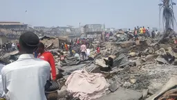 People observe burnt down structures