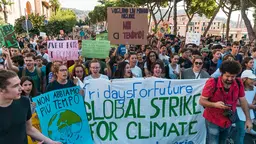 Hundreds of protesting young people march behind a sign saying "Global strike for climate change"