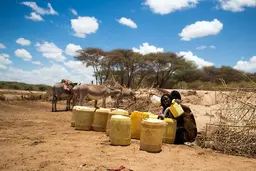 Woman filling jerry cans with water