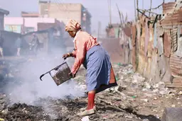A woman burns off plastic in an informal settlement