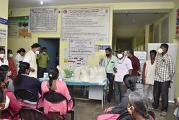 People sitting in front of a table with bags on it