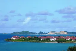 Landscape of an island with houses and vegetation surrounded by the sea.