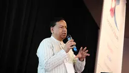Man speaks passionately into a microphone.