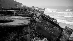 The edge of a cliff falls away into the water. 