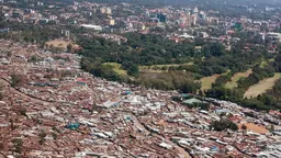 Aerial view of an informal settlement and an urban centre in the background
