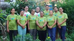 Group of people wearing green T-shirts pose for a picture.