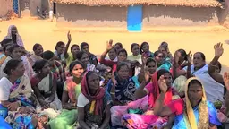 Group of women sit on the floor and raise their hands up.