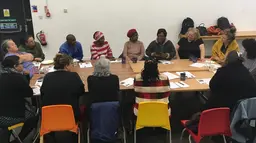 A group of women siting around a table.