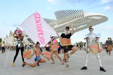 Five people posing with signs that read "gentrificado"