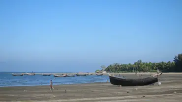 Small fishing boats just off the coast. Another boat on the beach in the foreground.