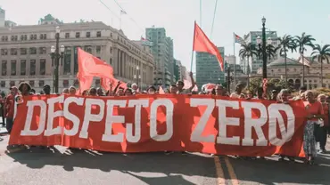 Group of people gathered for a protest in Sao Paulo, hoping a big sign that reads 'Despejo Zero'.