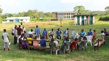 A large group of people sitting in a circle outdoors