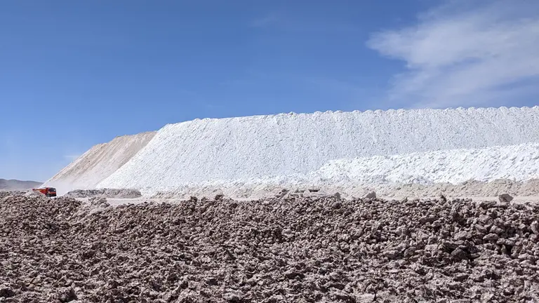  A salt mine, with a white cliff against a blue sky and a tiny lorry in the distance.