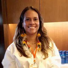 A woman in a white shirt smiling.