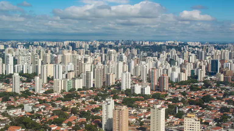 A view from high up of a city with tower blocks, framed by the sky.