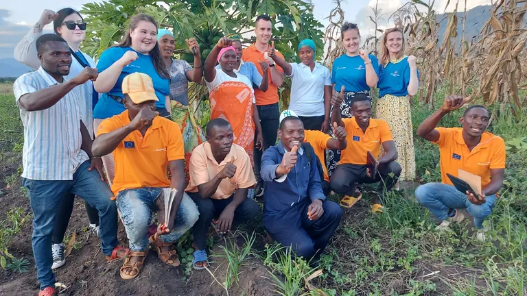 A group of young people with their hands up posing for a picture