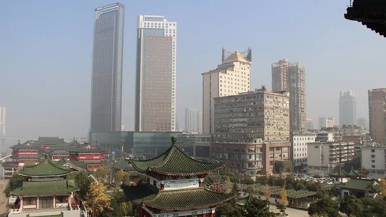 View of a city with traditional housing and two skyscraper in the distant background