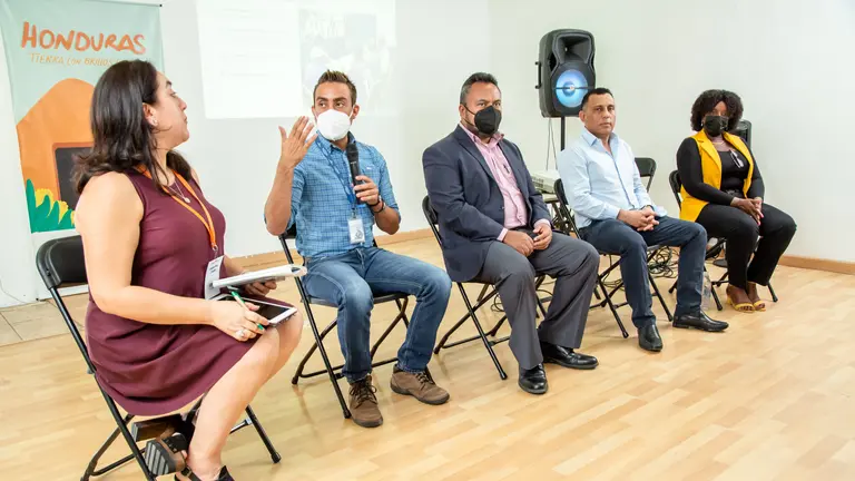 Five people talking to an audience