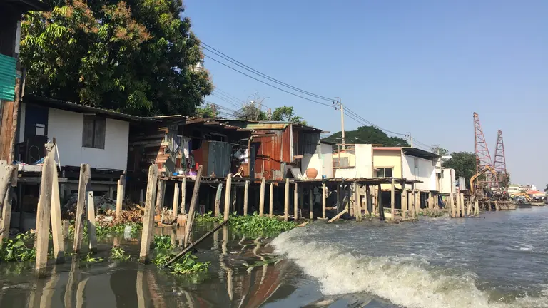 A body of water with houses on stilts next to it.