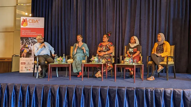 Five people siting on a stage