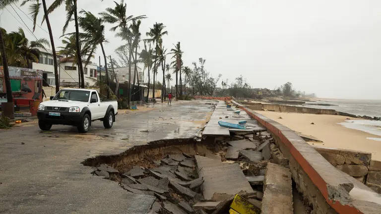 Car next to a sinkhole on a road