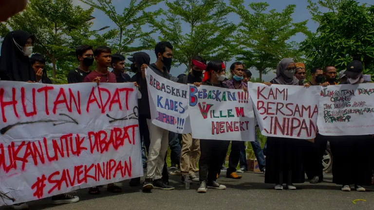 People holding banners written in Indonesian. 