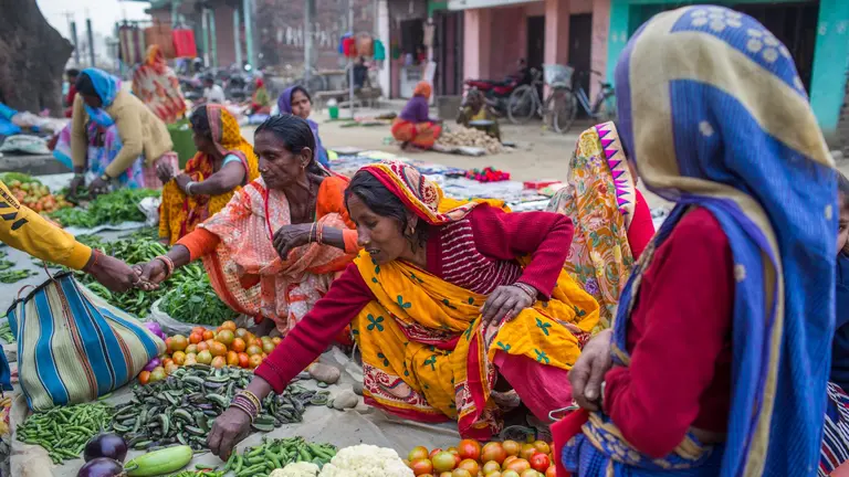 Vegetables street vendors sitting on the floor.