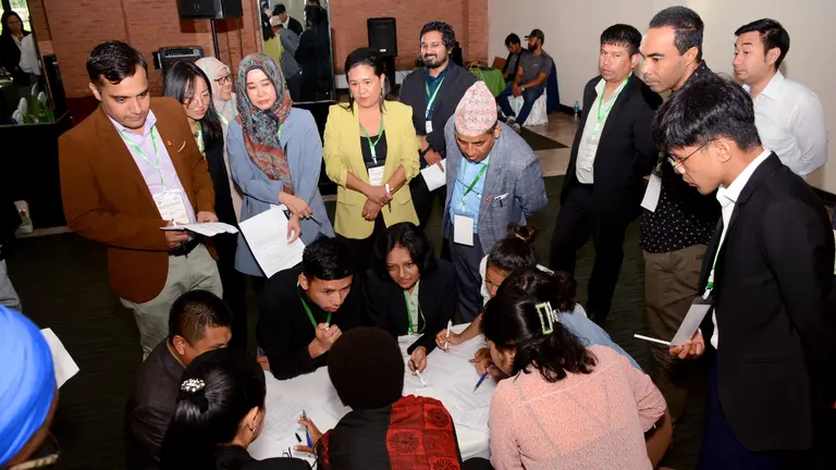 A group of people gathered around a table with papers.