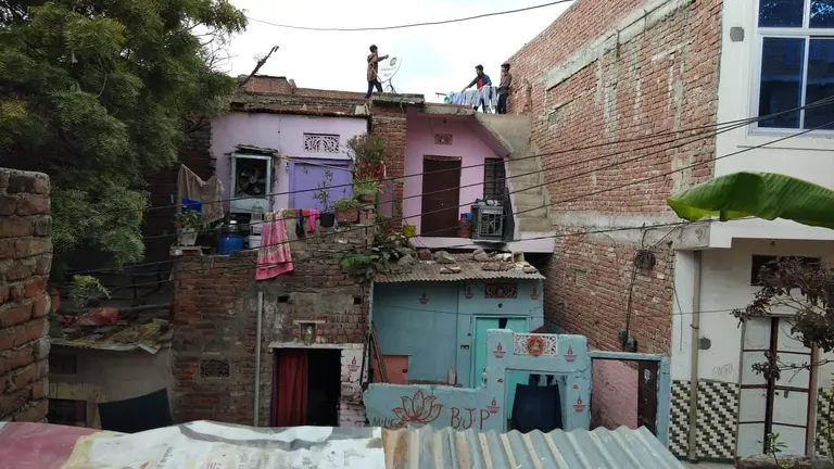 People put out washing on a line on top of a house 