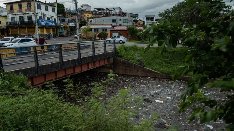 A bridge crossing a river filled with dirt and flowing water.