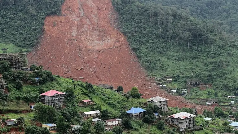  Landslide sweeps over residential area, burying houses and buildings in its path.