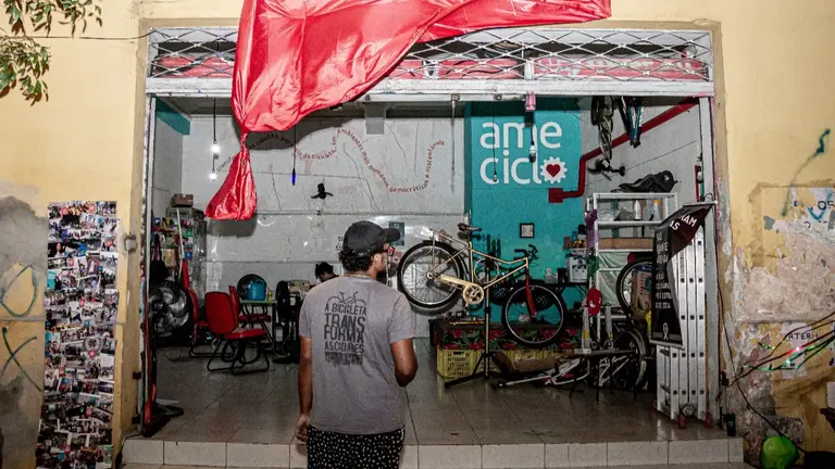 A man standing in front of store, looking at a display of bicycles and accessories.